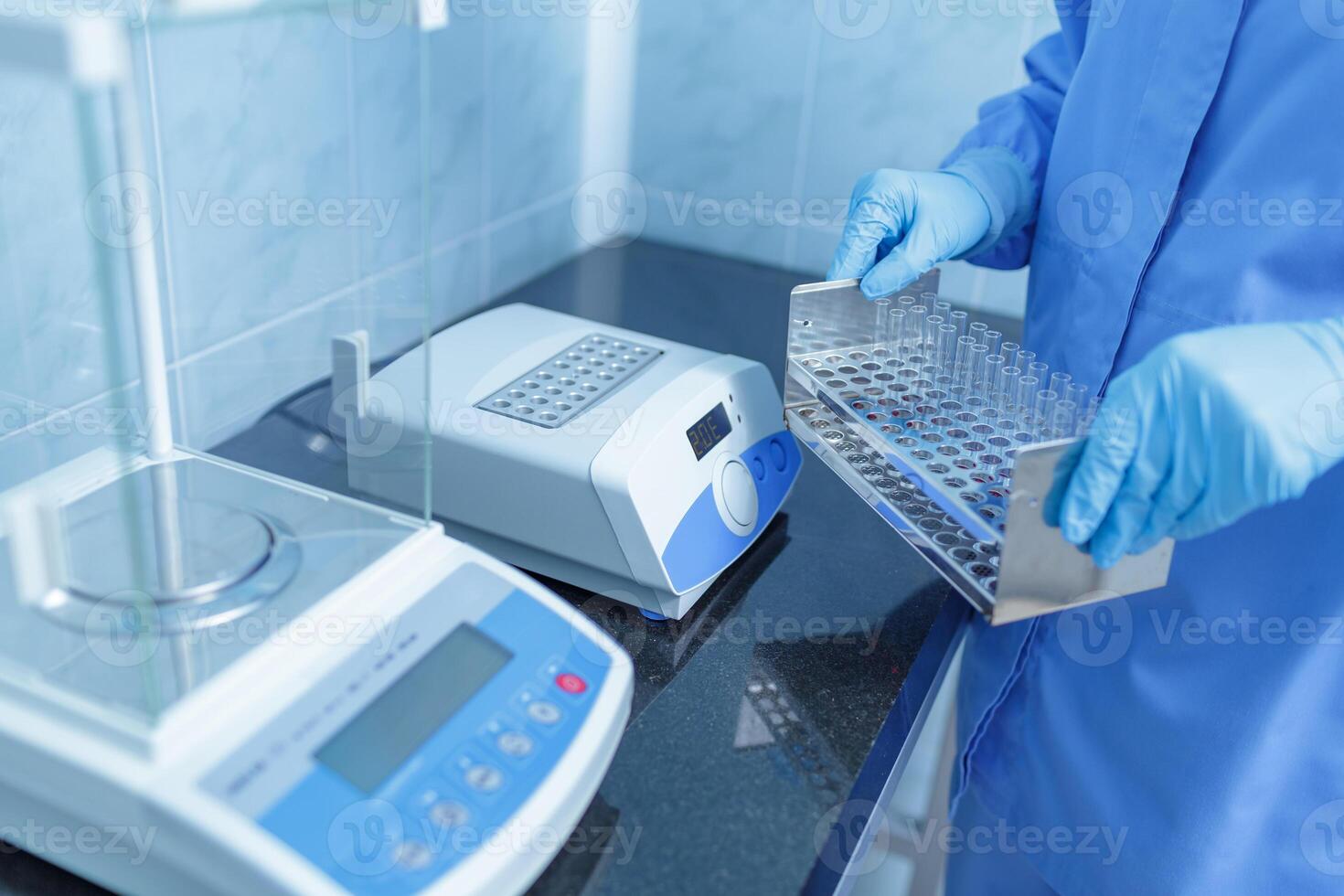 Lab Technician Handling Test Tube Rack with Digital Lab Equipment for Medical Diagnostics and Research photo