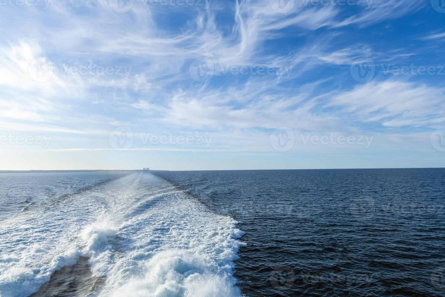 a view of the wake of a boat on the ocean photo