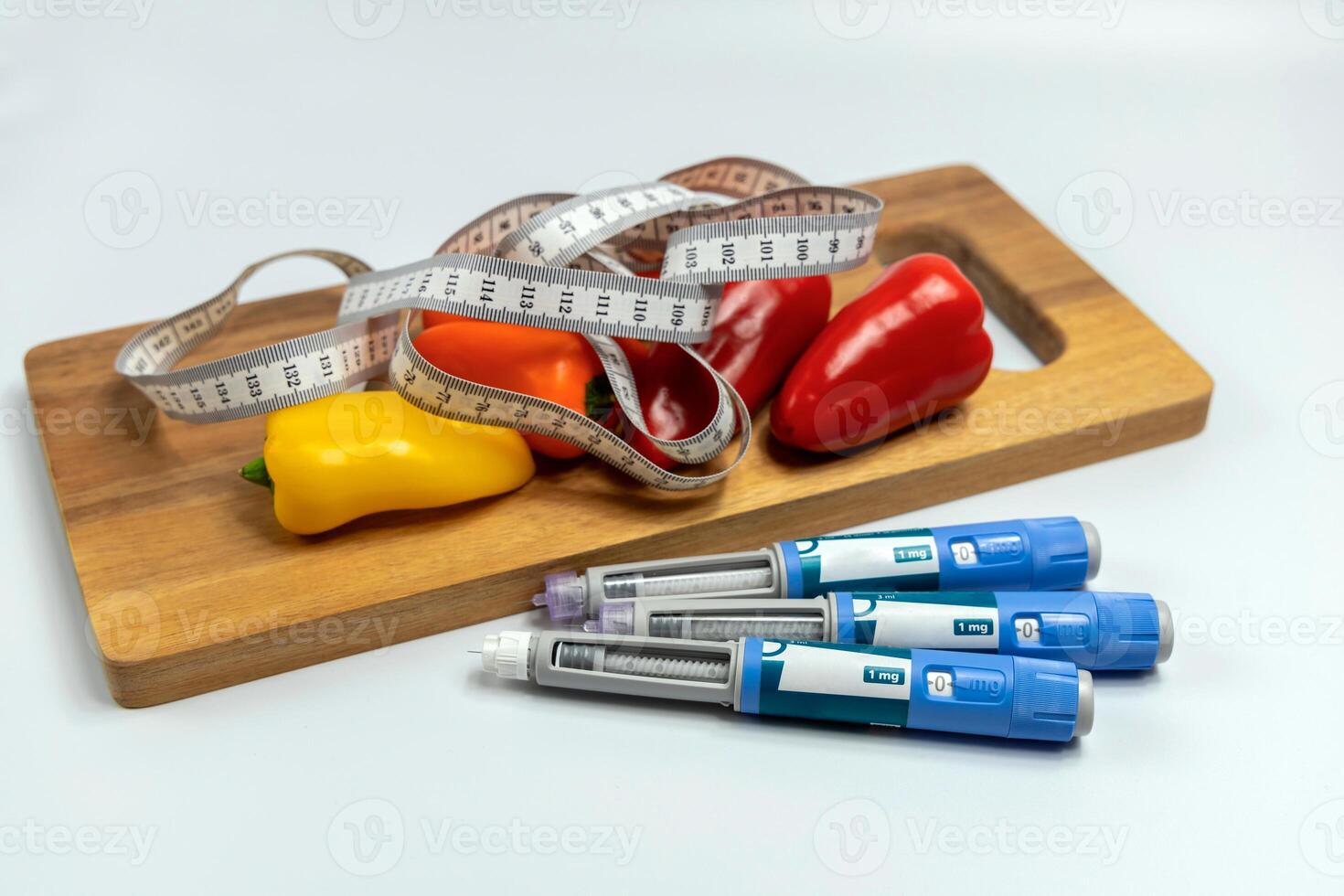 Ozempic Insulin injection pen for diabetics and weight loss and a cutting board with vegetables and a measuring tape. photo