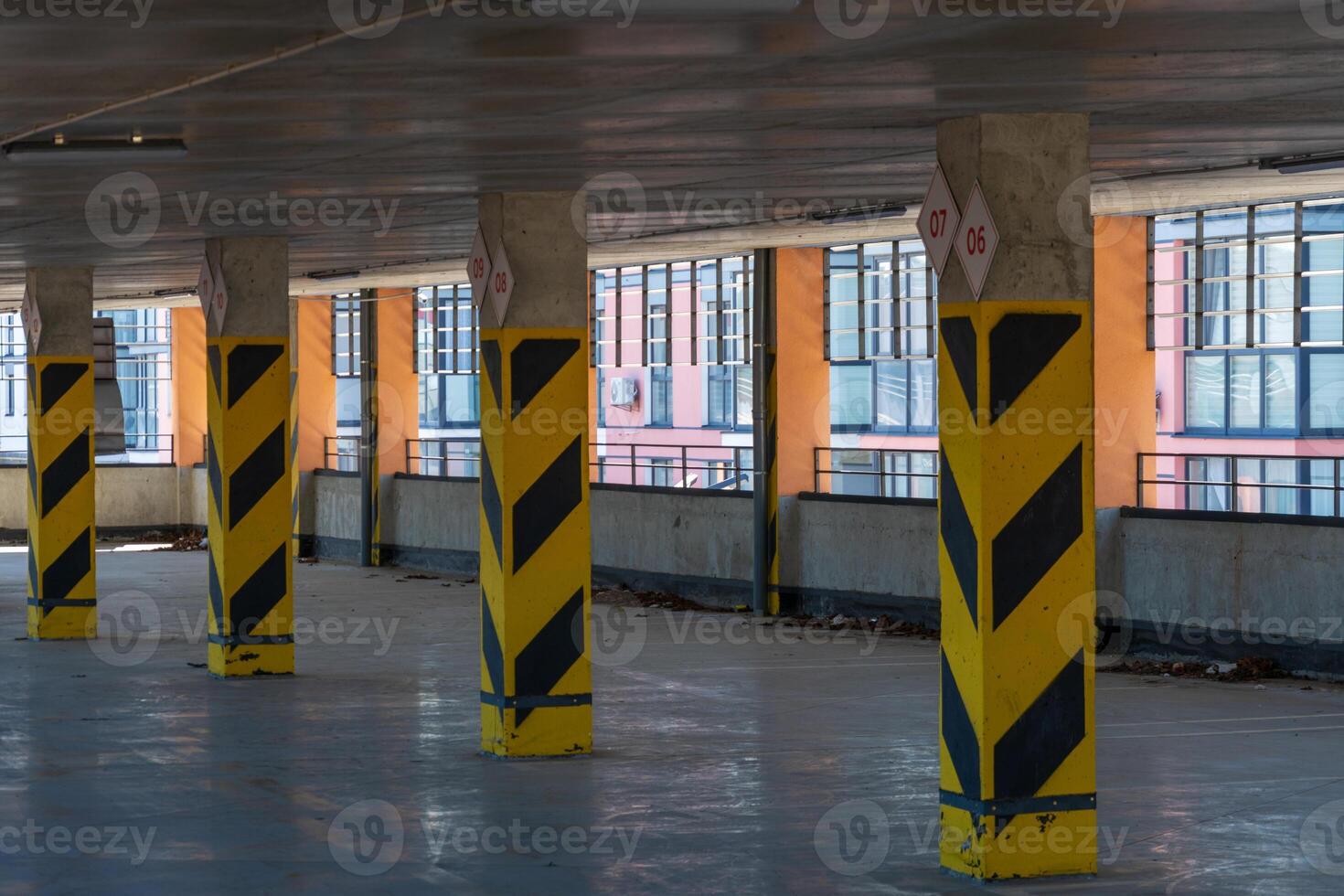 Concrete Support Pillars with Yellow and Black Warning Stripes in Garage photo