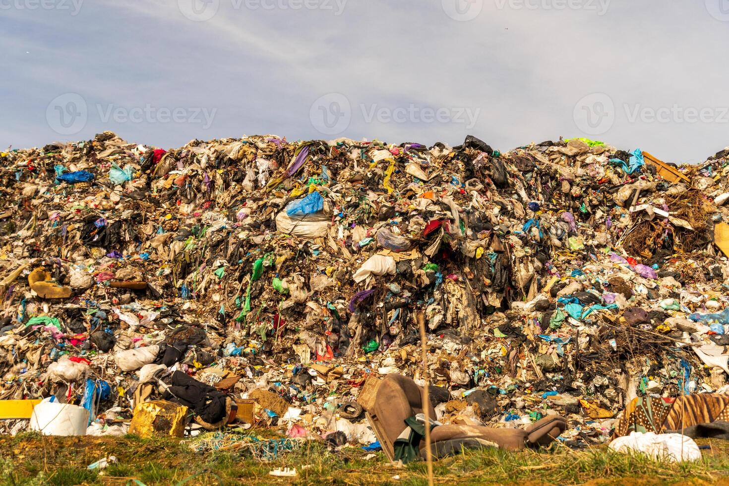 Extensive Landfill Site Overflowing with Discarded Waste Under a Cloudy Sky photo
