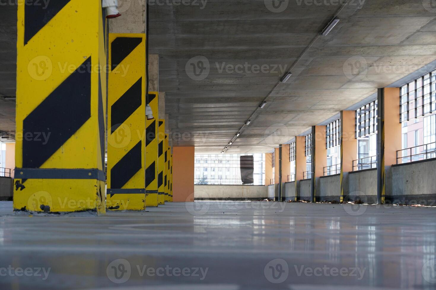 Parking Garage Interior with Yellow Hazard Stripes on Concrete Support Pillars photo