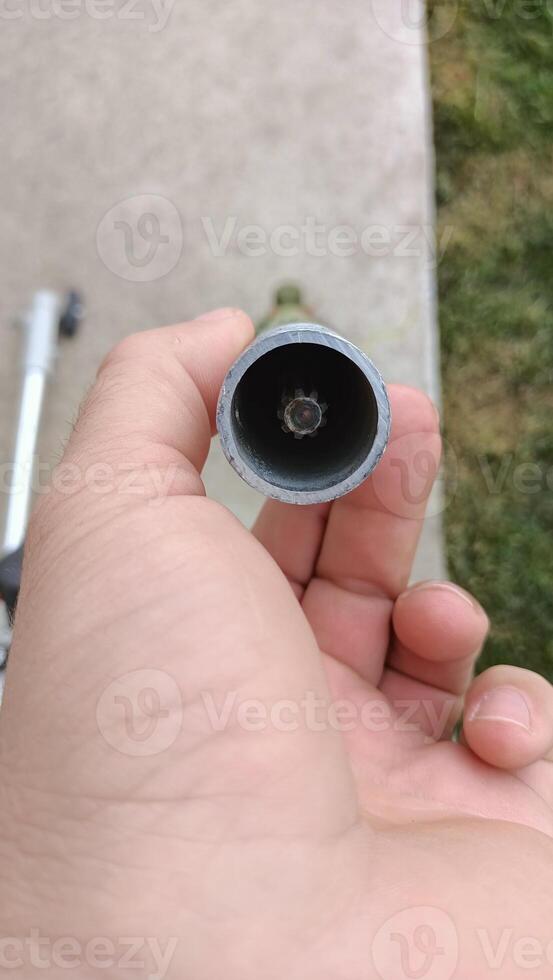 A Detailed CloseUp of a Pipe Opening Captured with the Help of a Hand for Analysis photo