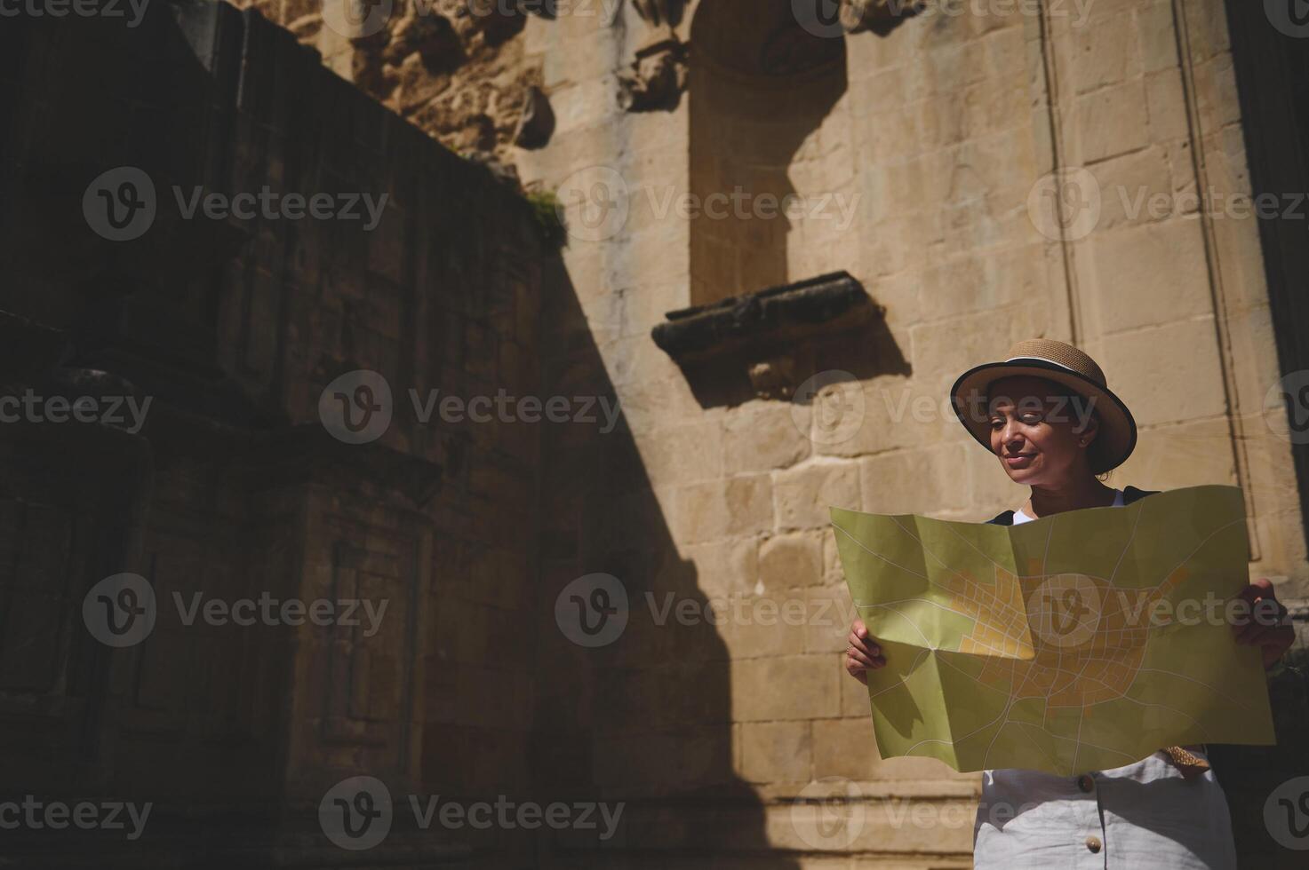 Woman Exploring a Historic City Street with a Map in Hand photo