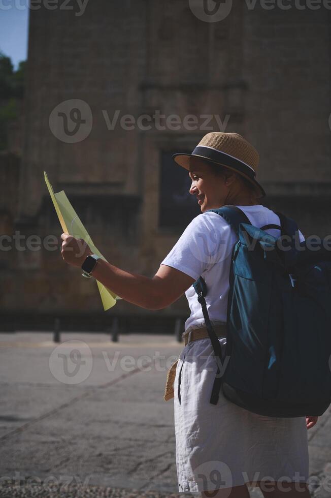 Woman Exploring Historic City Streets with a Map on a Bright Day photo