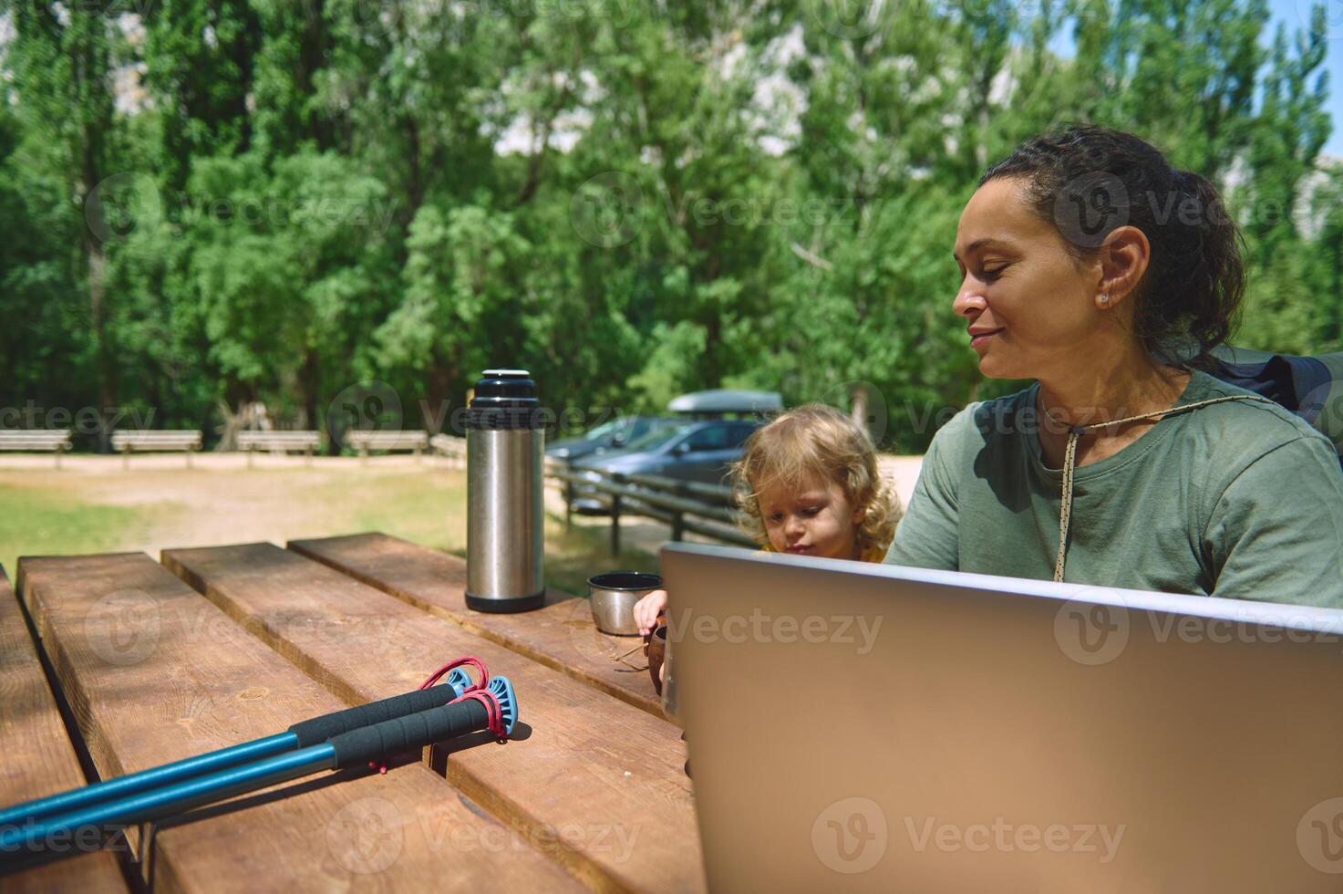 Woman Working Remotely in Nature With Child at Scenic Outdoor Park photo