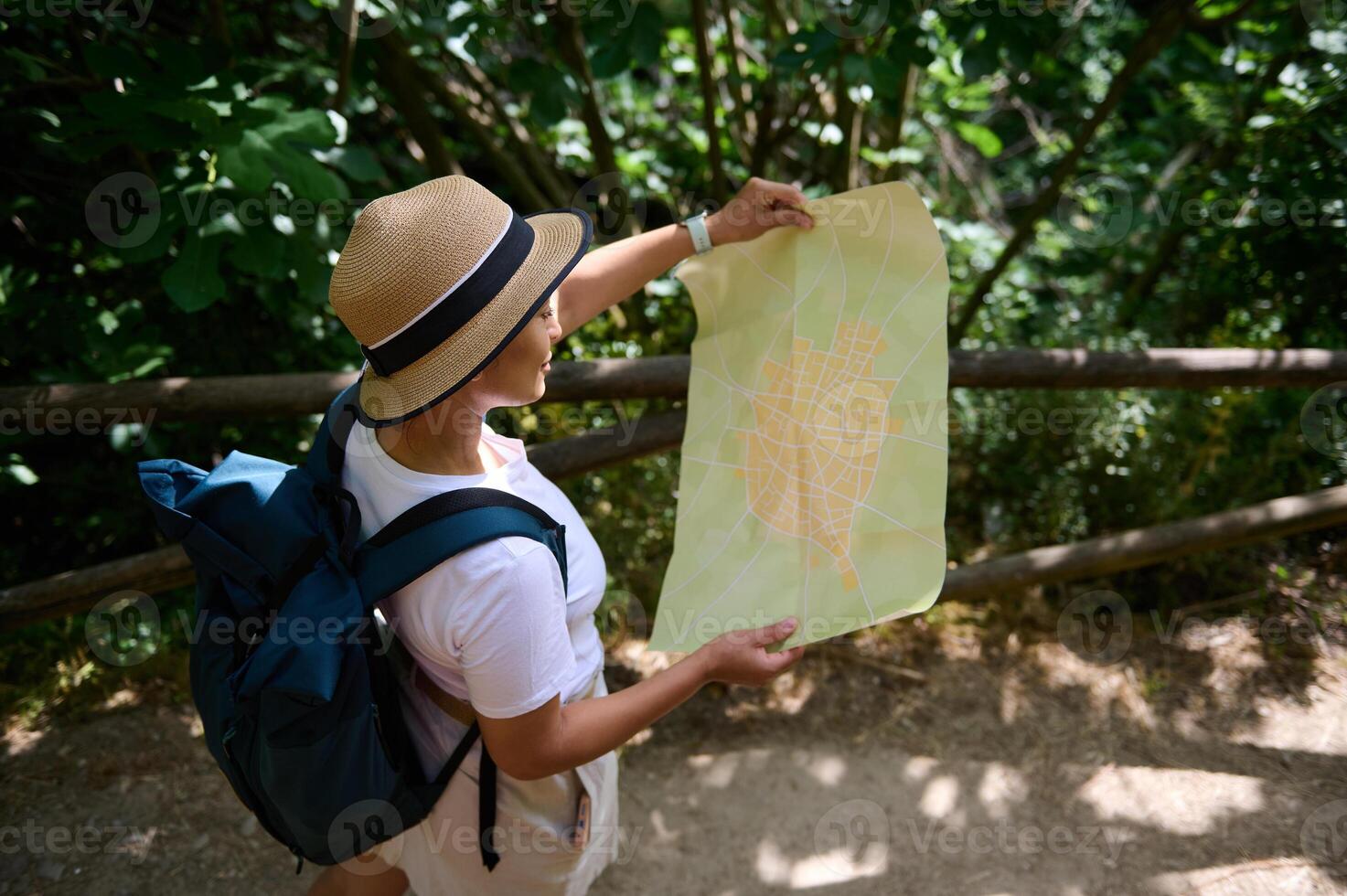 Woman Explorer Holding Map in Forested Pathway During Daytime Journey photo