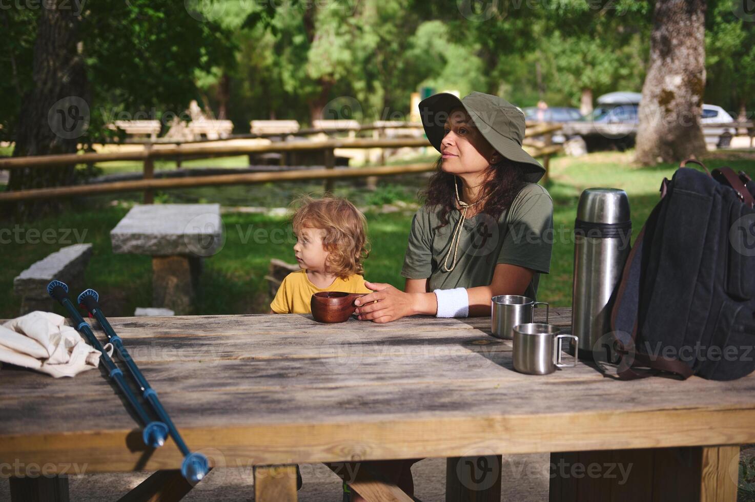 Mother and Child Enjoying Nature at a Picnic Table in a Forest Campground photo