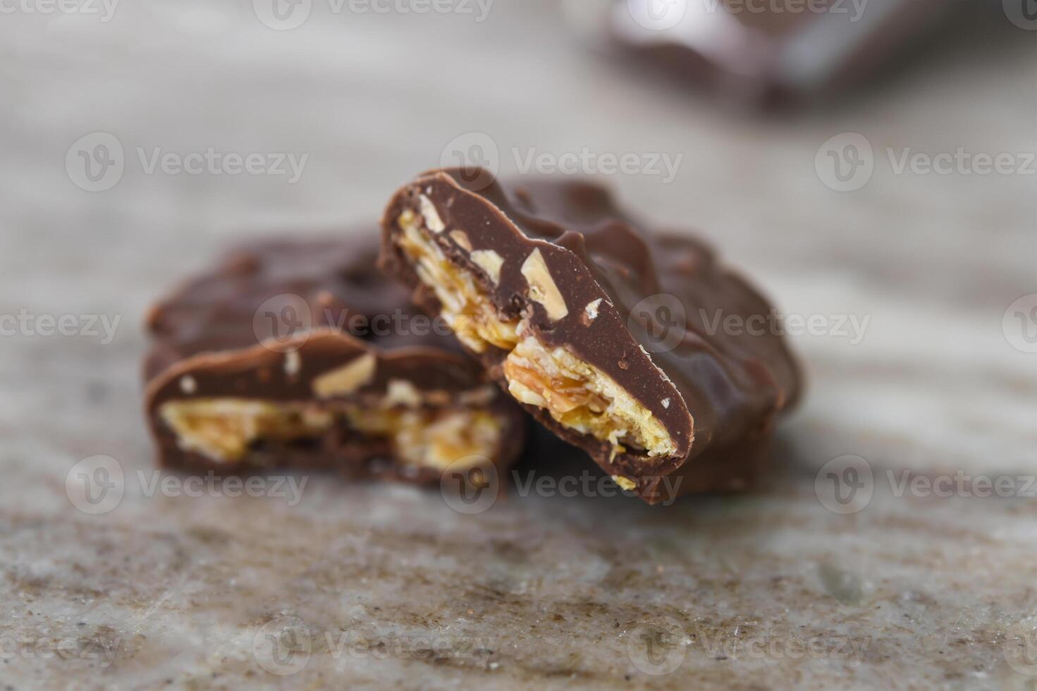 Chocolate Nut Clusters on Marble thick layer of chocolate coating highlights the indulgence closeup side view of sweet treat photo