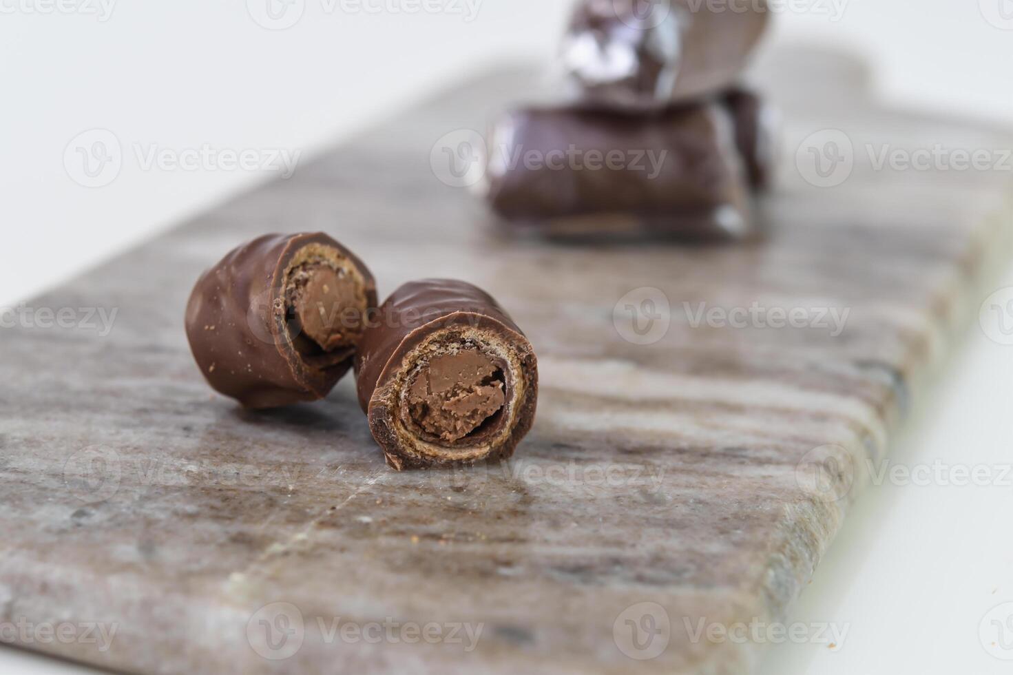 Chocolate Filled Wafer Rolls on Marble reveal a creamy chocolate filling within the crisp wafer side view of sweet snack photo