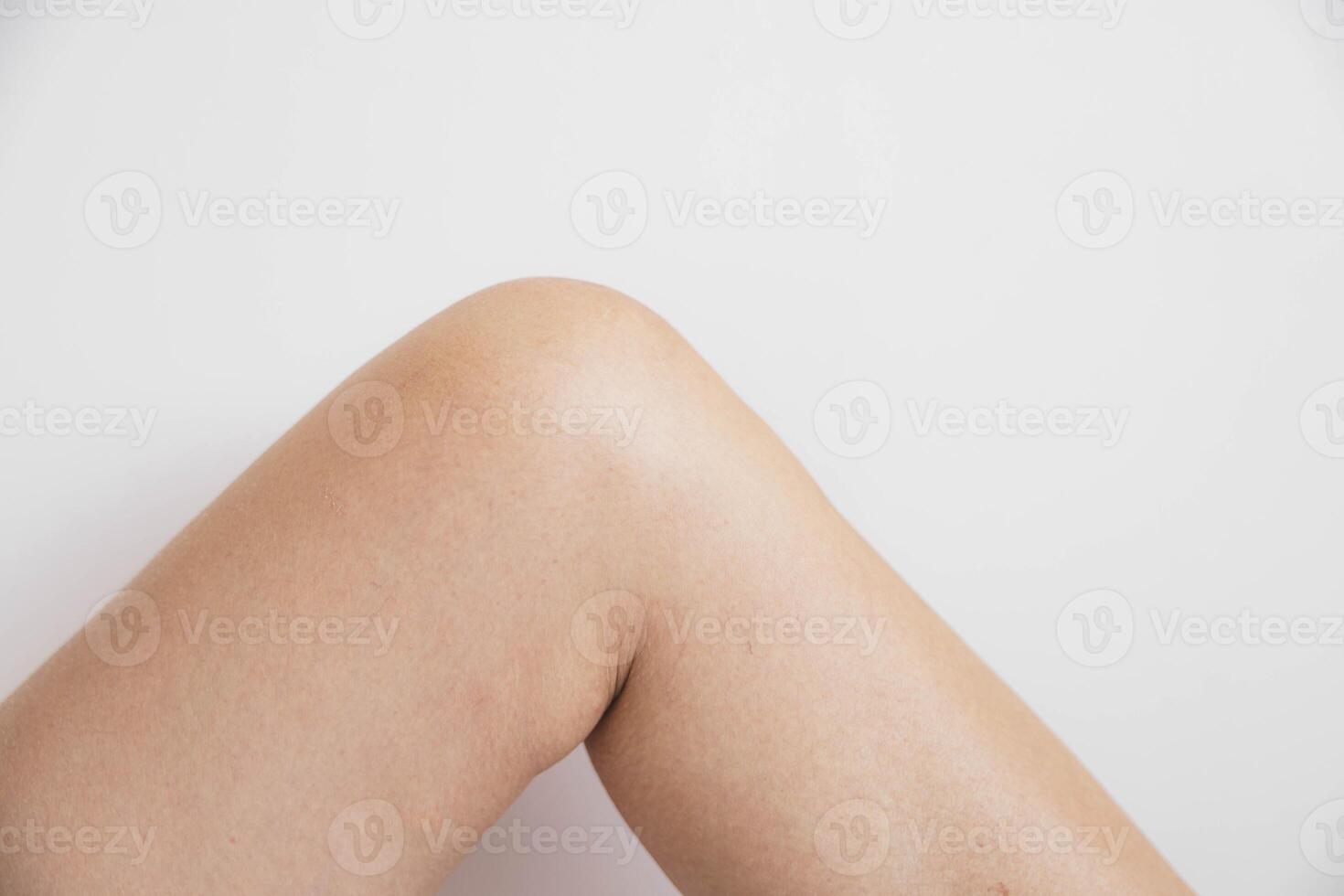 close-up of bent female knee on a white background, healthy smooth skin, minimalistic composition, concept of joint health, anatomy, skincare, or physical therapy photo
