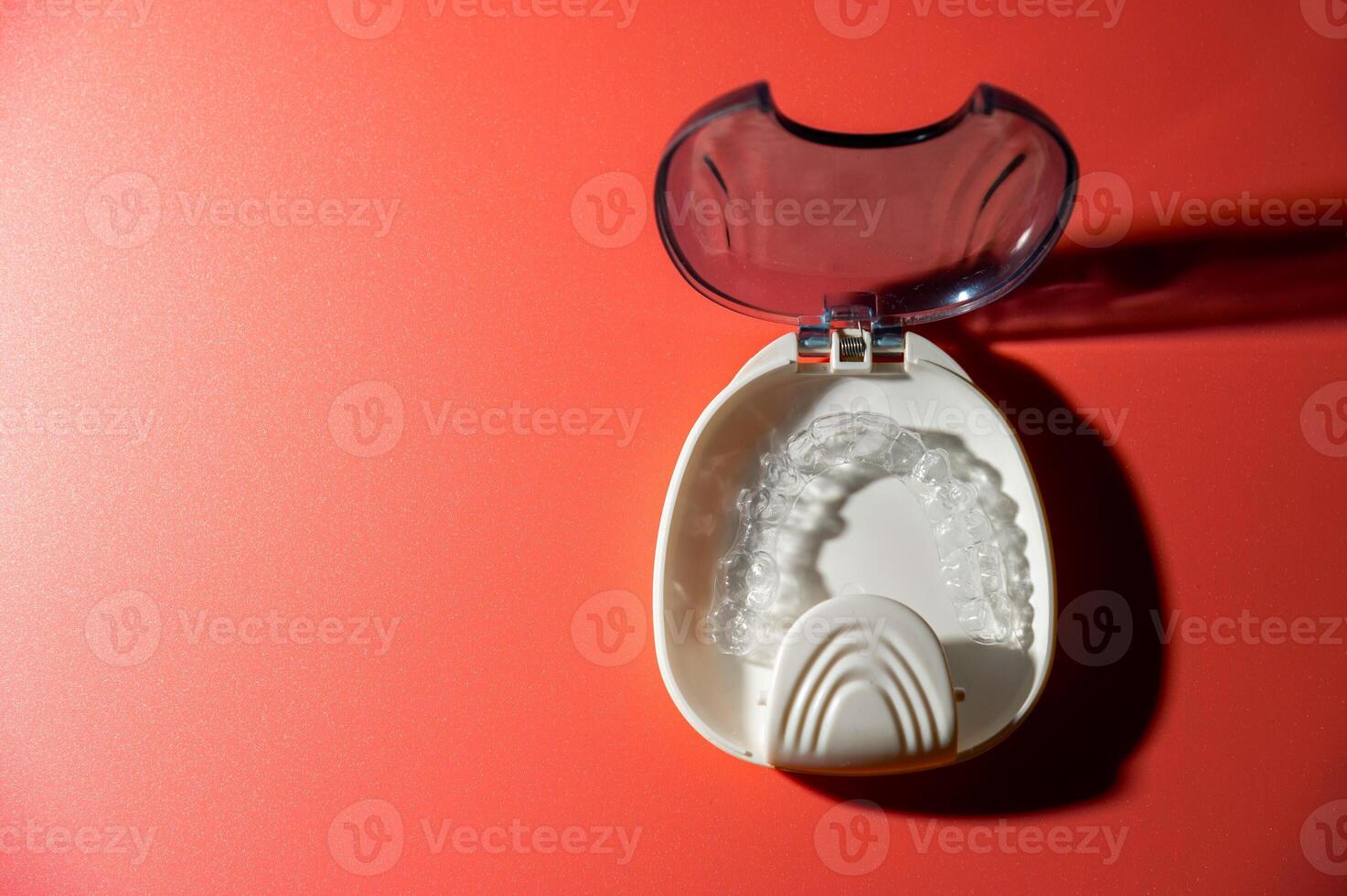 Transparent dental aligners lie in a case on a colored background. Aesthetic and comfortable correction of jaw bite. Copy space photo