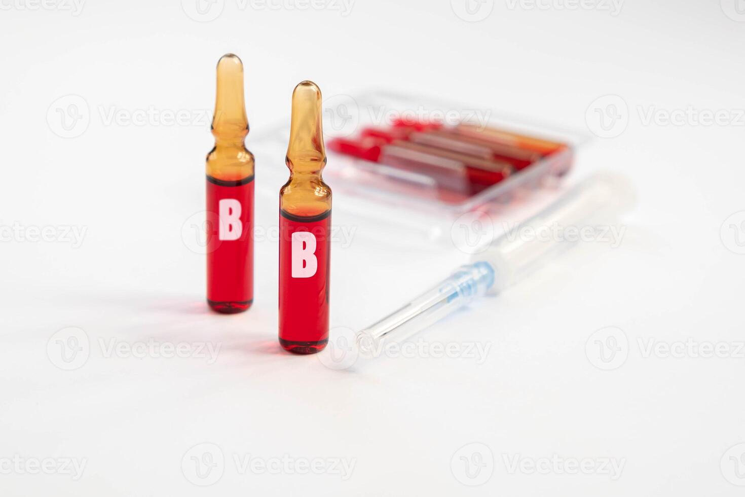 Injection of vitamins B. Ampoules with red liquid. Copy space photo
