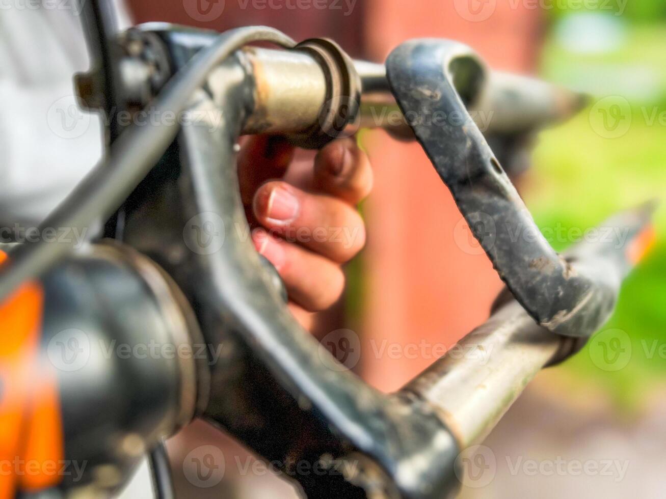 Mechanic holding and inspecting damaged handlebars of mountain bike photo