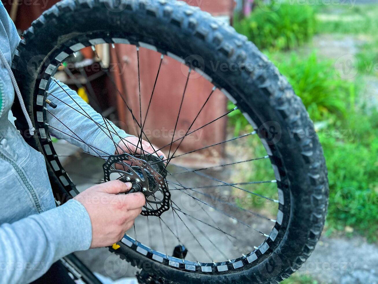 Mechanic repairing bicycle wheel with disc brake rotor photo