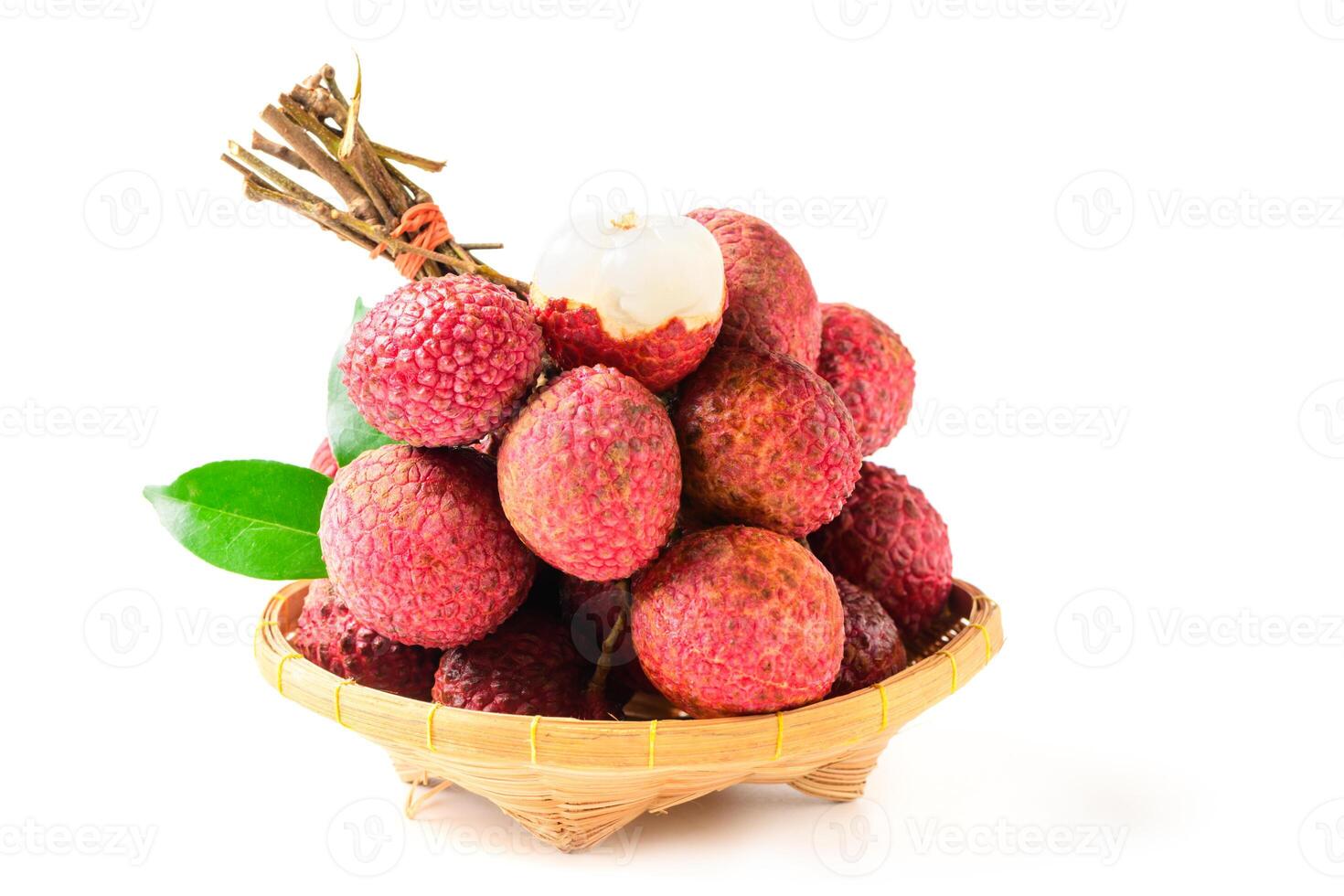 Juicy Lychee with cut in half and leaves on bamboo basket isolated on white background. photo