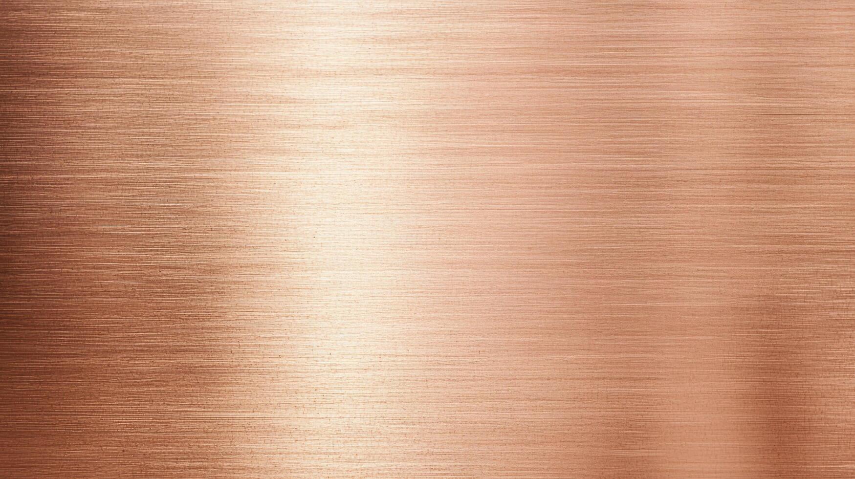 Brushed copper texture with horizontal grain and soft reflections, showing warm metallic tones and fine material lines. photo