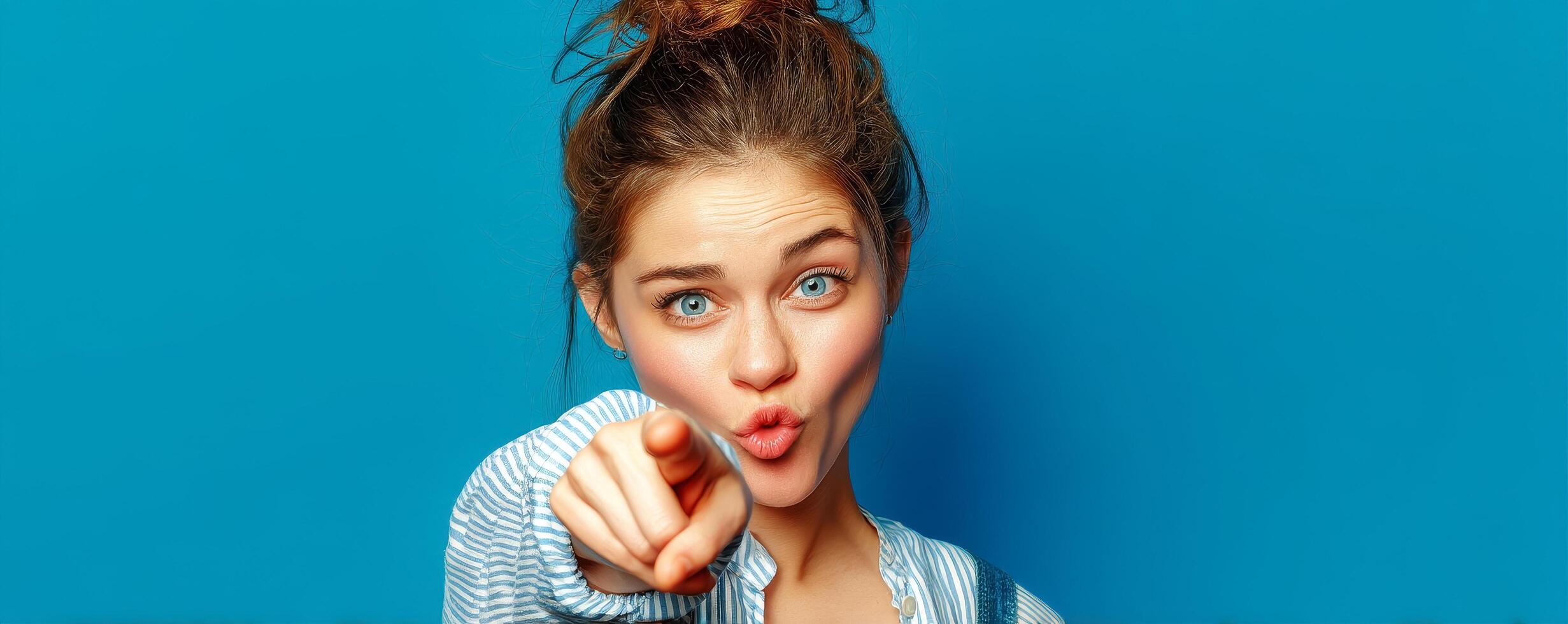 Playful female pointing across screen studio portrait blue background. photo