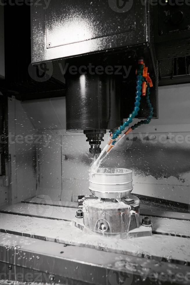 Auto CNC turning with robot drill milling factory with water coolant streams. The mold and die manufacturing process by CNC machining center. photo