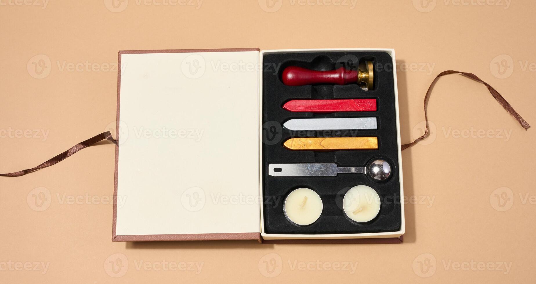 Wax seal kit including wax sticks, spoon, candles, stamp and sealed scroll placed on a neutral background. photo