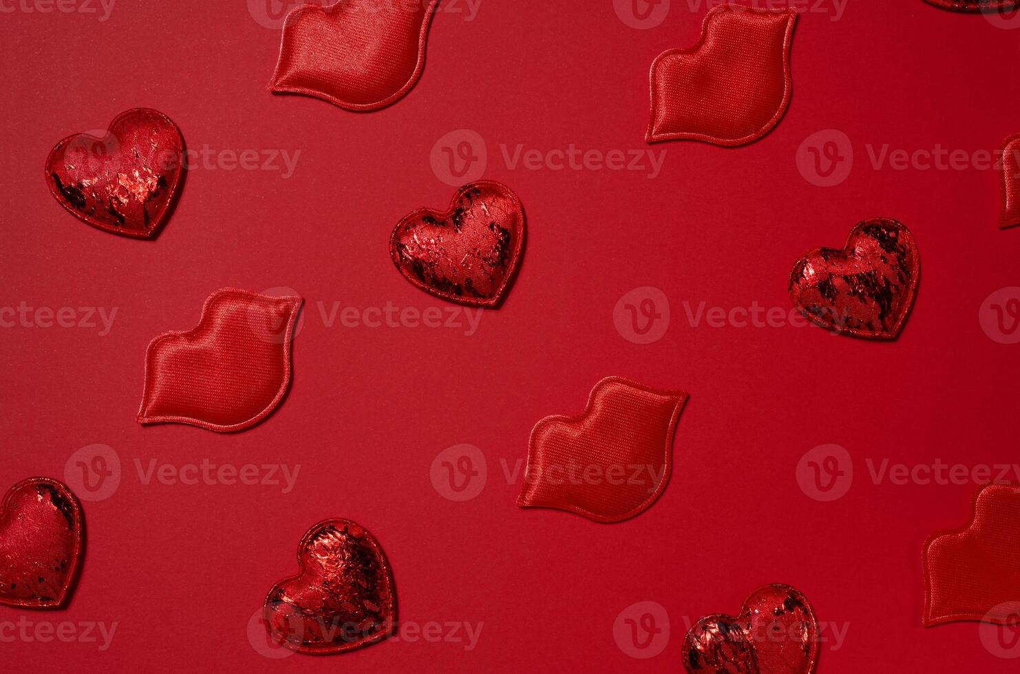 Red decorative hearts and lips randomly placed on a bright red background photo