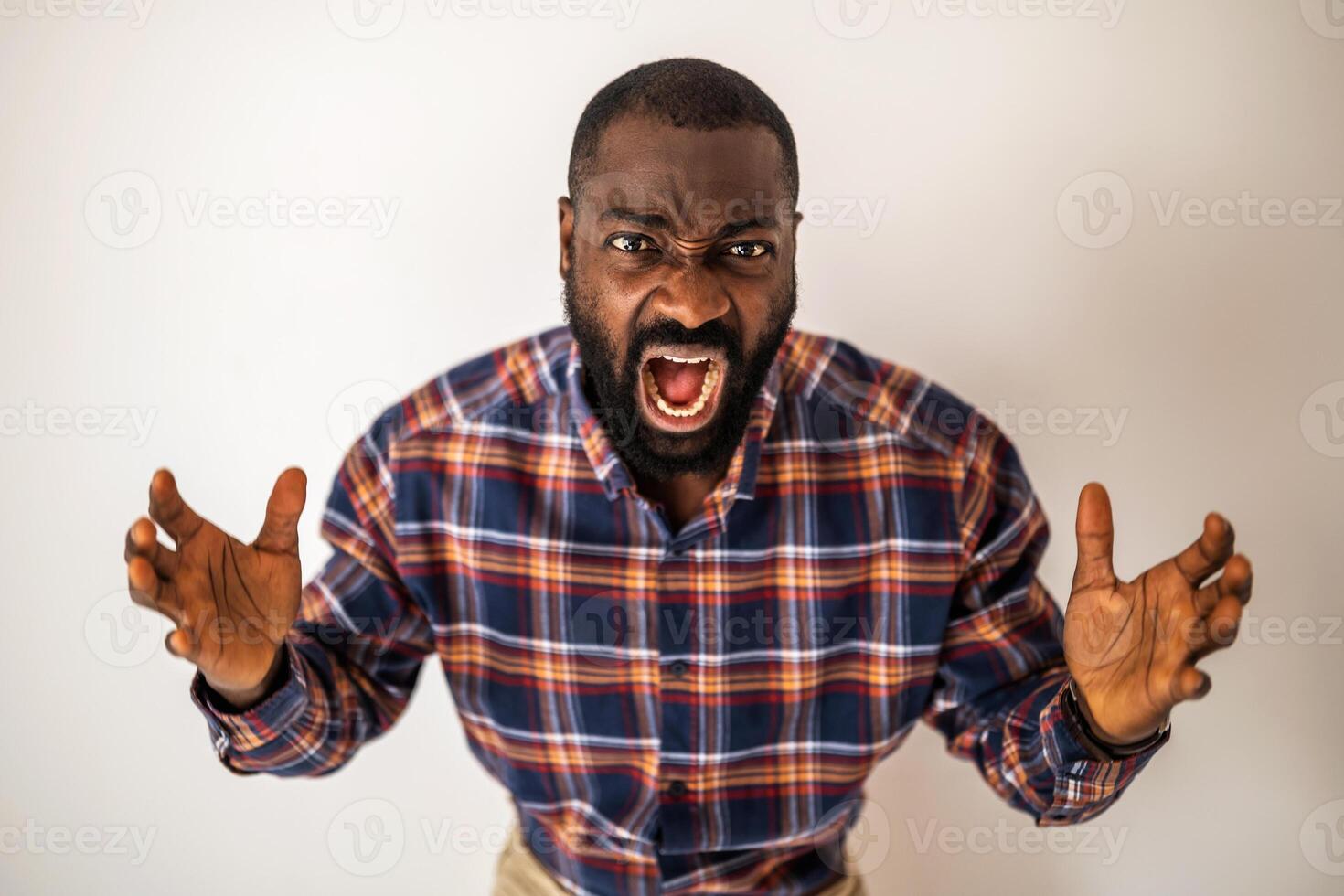 Portrait of emotionally stressed and angry black man who is shouting. photo