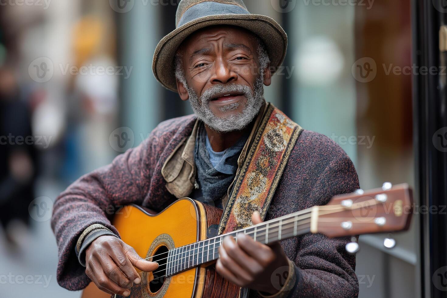 Senior street musician playing acoustic guitar in urban setting photo