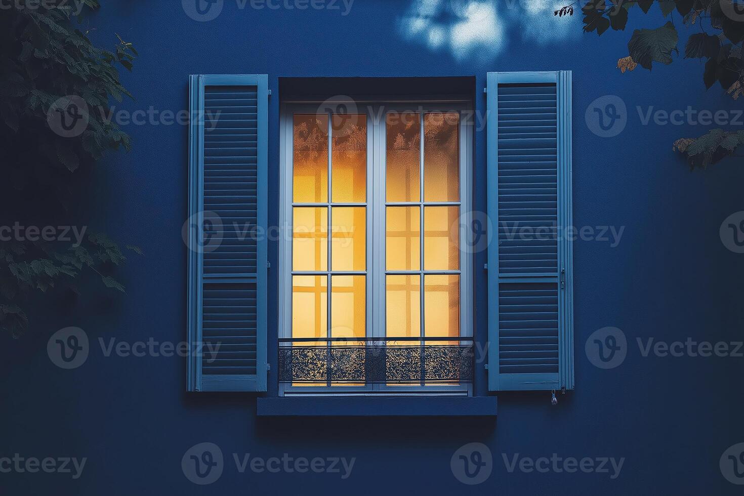 Illuminated window shining in the twilight on a blue wall photo