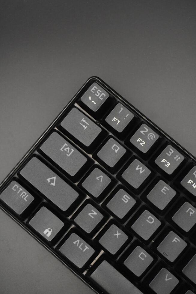 Corner of a black mechanical keyboard with a black background photo