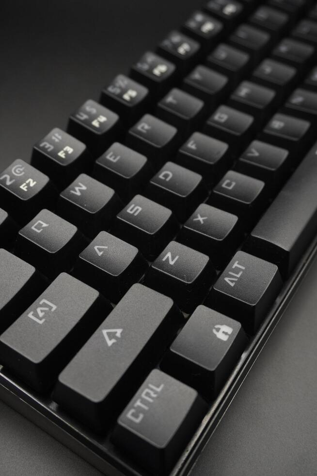 The corner of a black mechanical keyboard with a black background photo