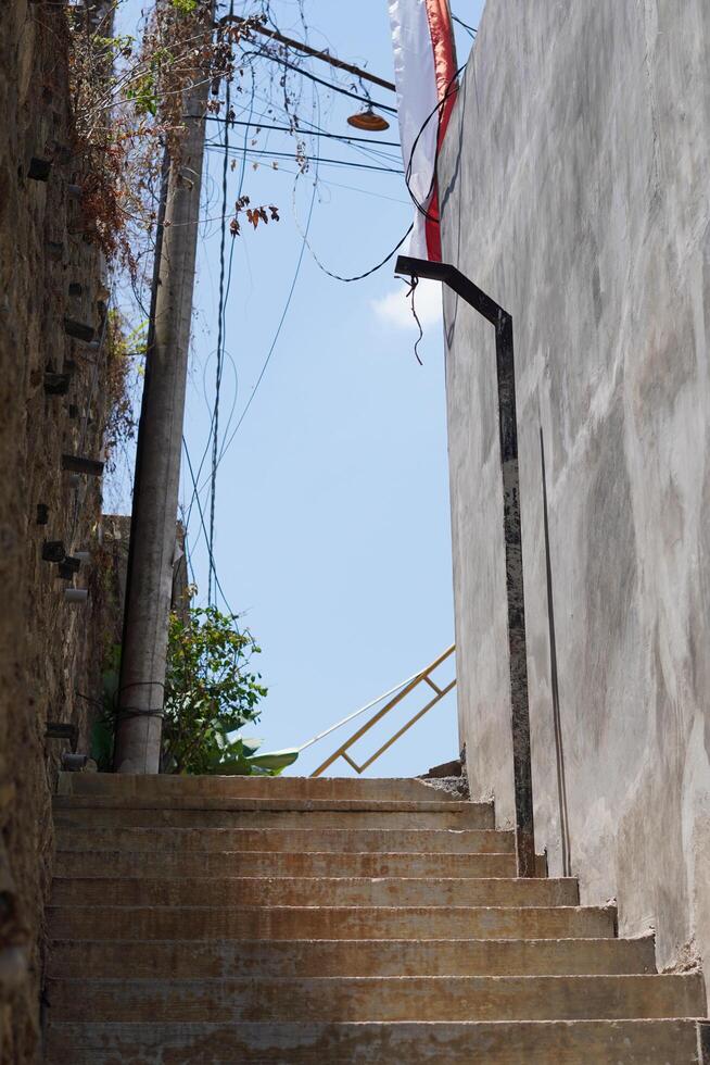 A street with stairs for pedestrians that is quiet during the day photo