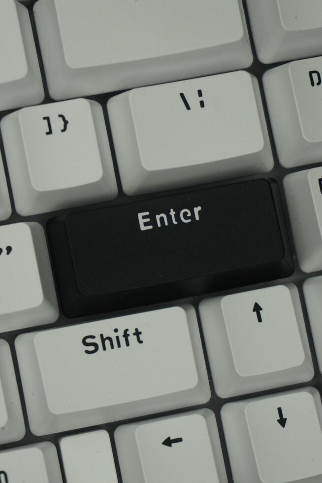 The black enter key on a mechanical keyboard with a monochrome theme in close up mode photo