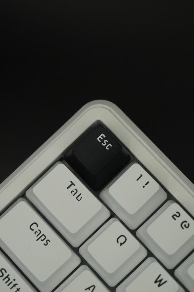 Black escape key on a mechanical keyboard with monochrome theme with black background photo