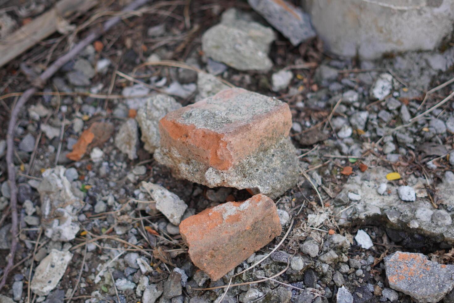 Broken red bricks that have been cemented on top of gravel photo
