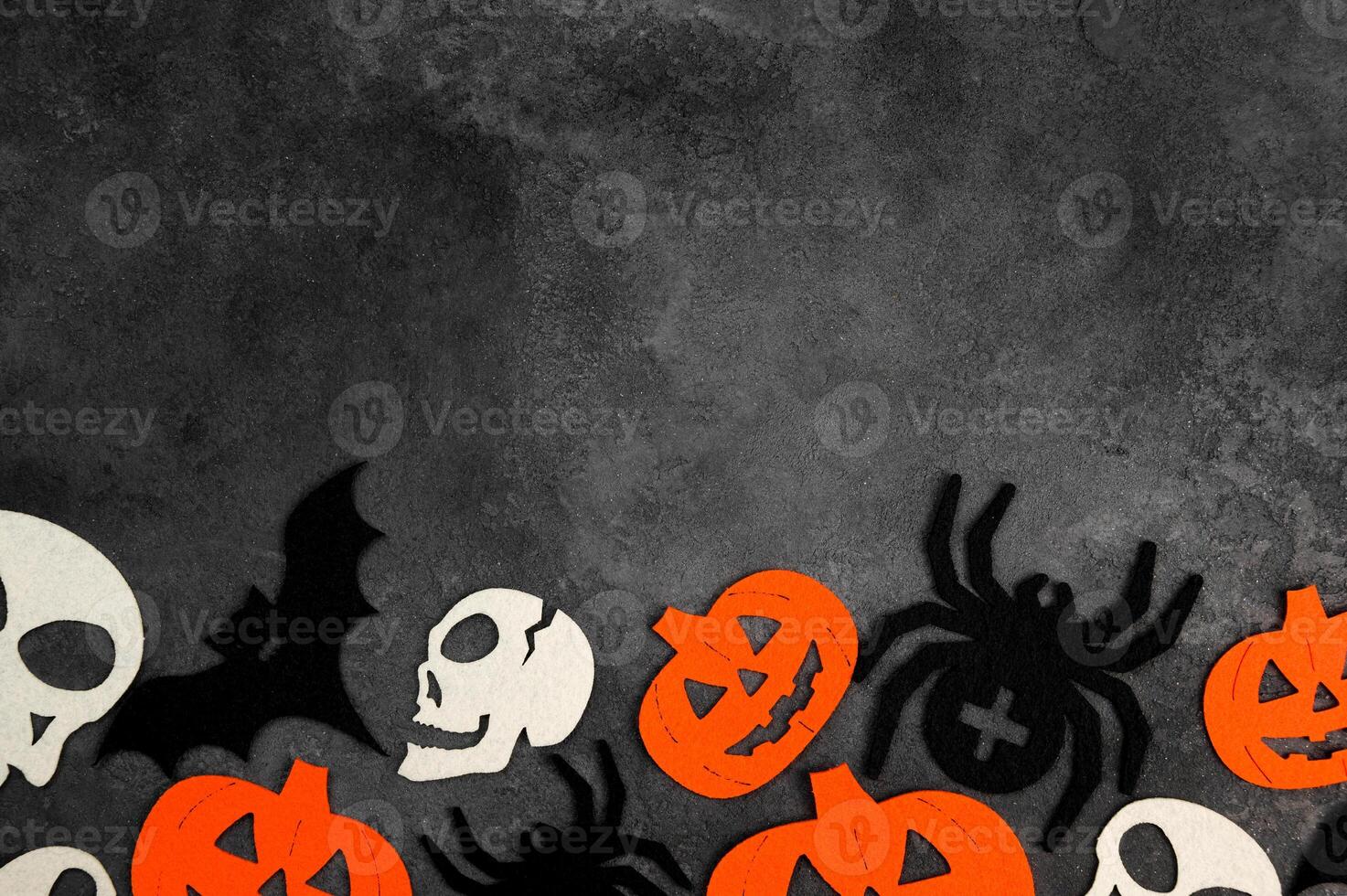 Halloween banner with bats,spiders,pumpkins and skulls on dark concrete background. photo