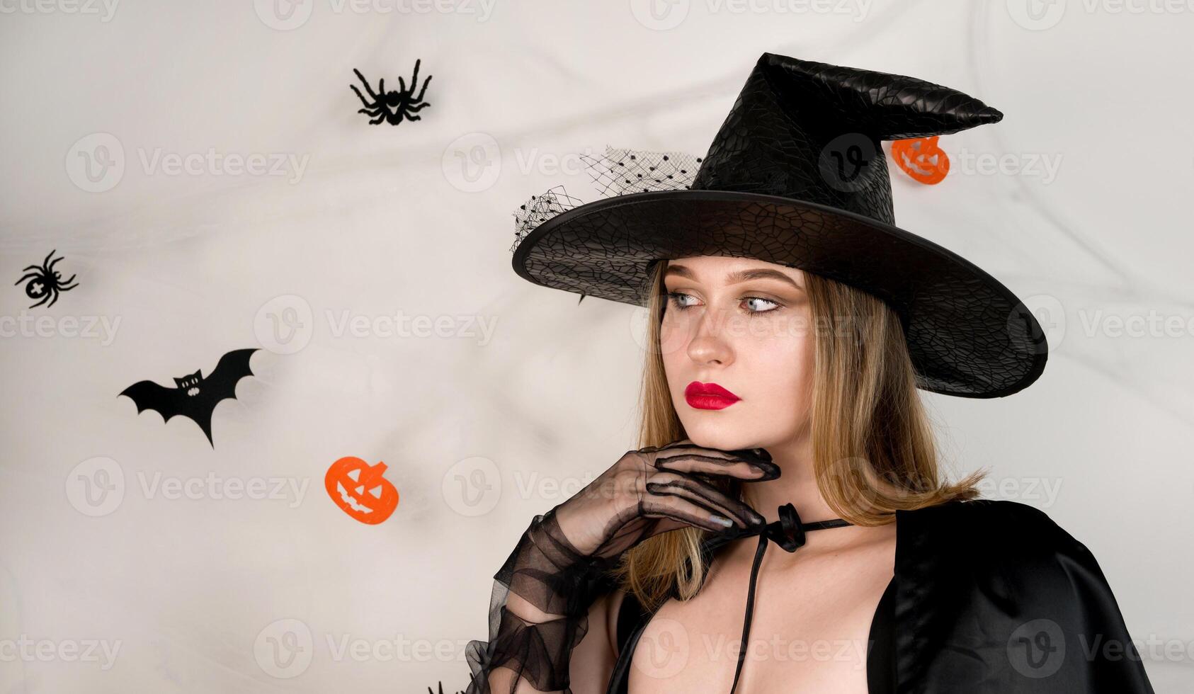 Halloween banner with cute mysterious girl dressed as a witch lookinf at empty space.Promotion banner with place for text photo