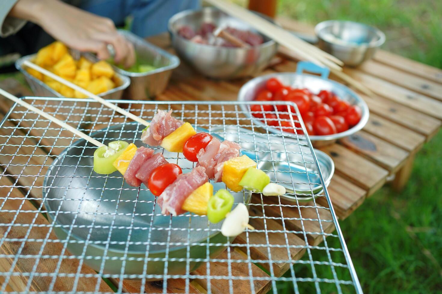 A person is cooking skewers of meat photo