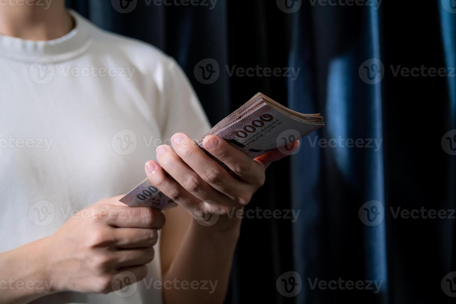 A person is holding a stack of money in their hand photo
