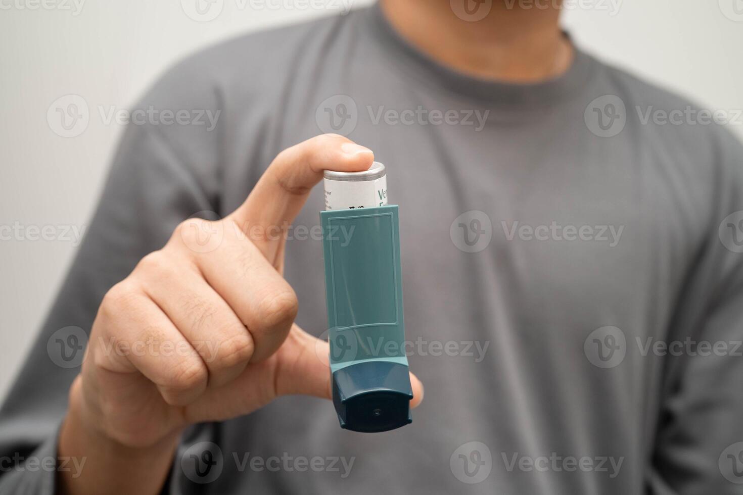 Asthma chronic obstructive pulmonary disease COPD, Asian young man using metered dose inhaler MDI. photo