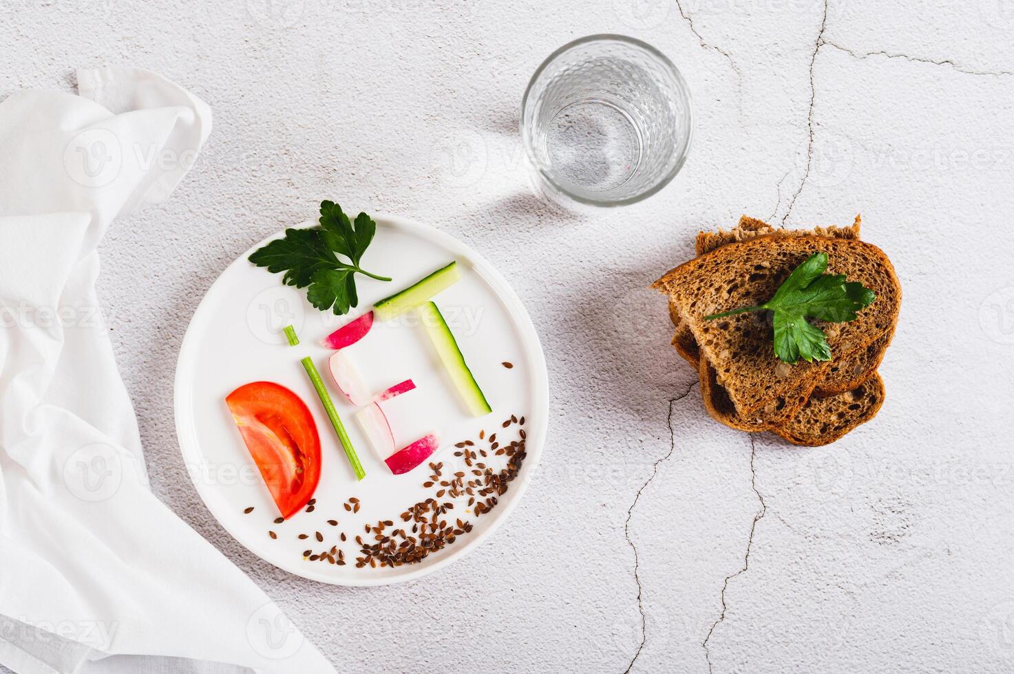 Concept diet on a plate of low-calorie foods on the table top view photo