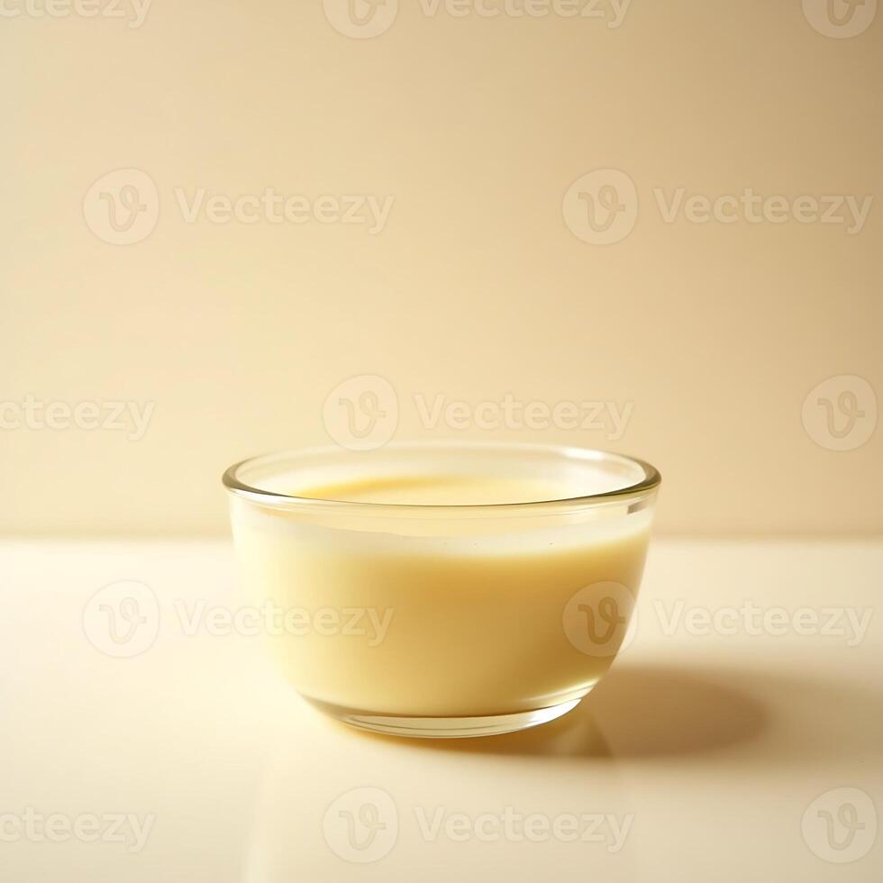 Serving Custard in Glass Bowl Against Plain Background photo