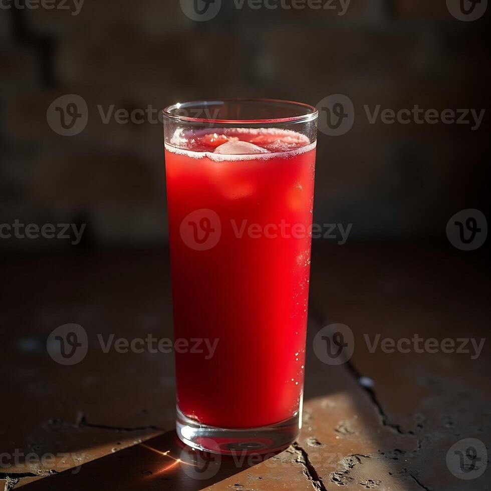 Refreshing Red Drink with Ice in Glass on Rustic Table photo