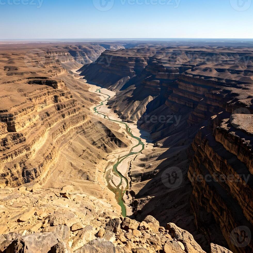 The canyon is wide and has a river running through it photo