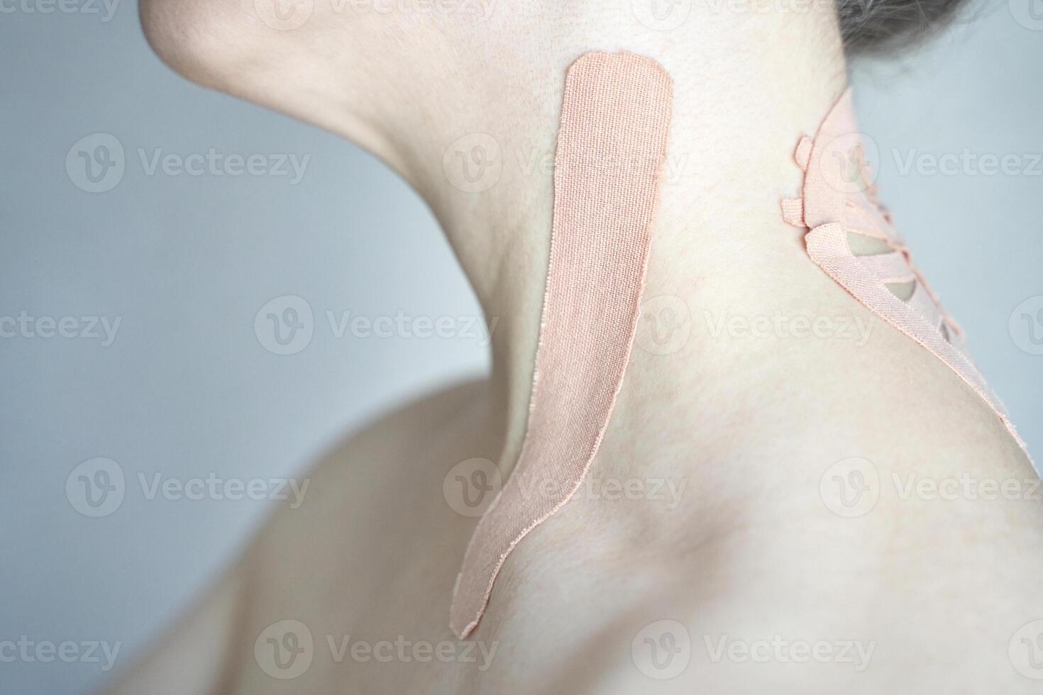 Female neck with kinesiology tape for pain relief and posture support. photo