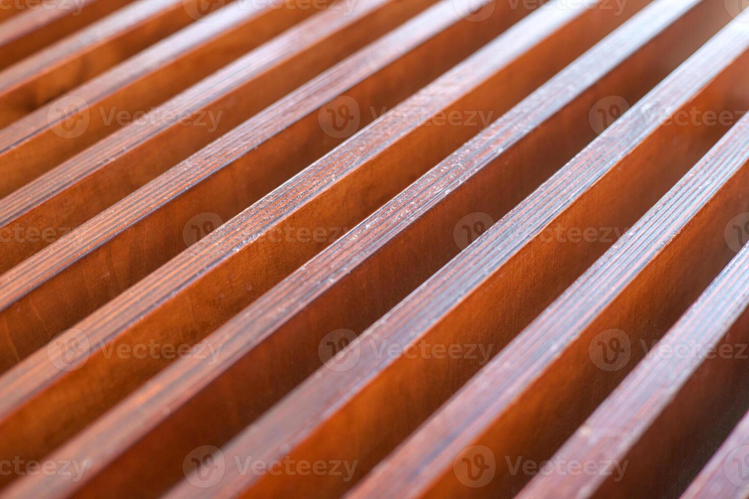Close-up of wooden slats with regular pattern and warm natural tones in abstract design. photo