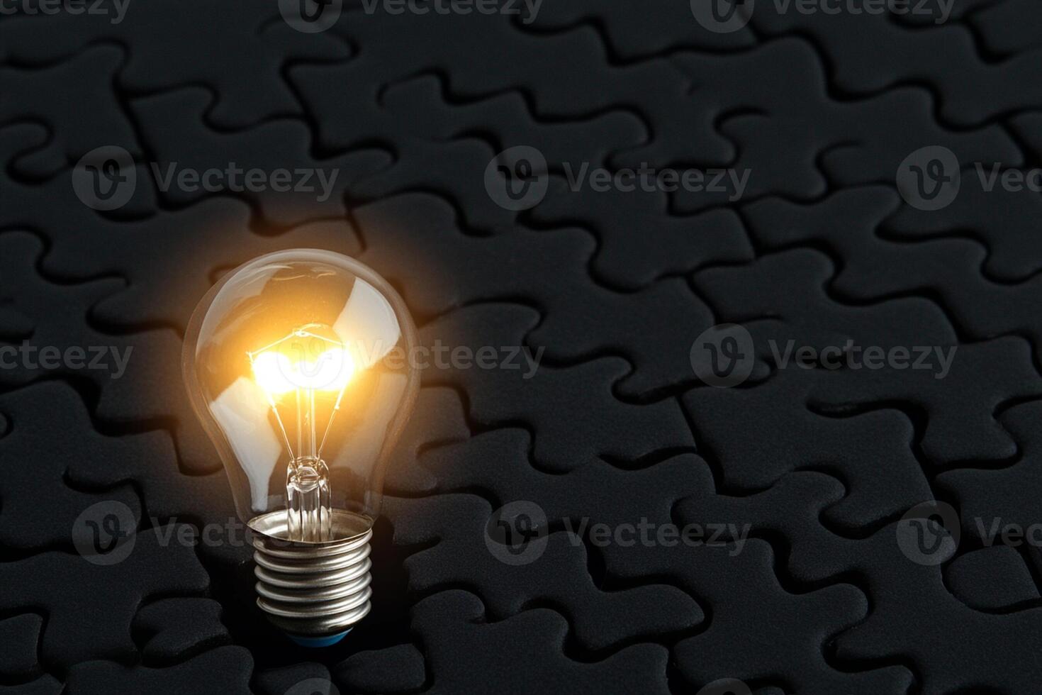 A light bulb is shining on a puzzle piece photo