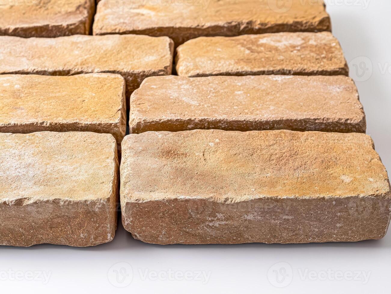 Row of tan bricks are laying on a white surface photo