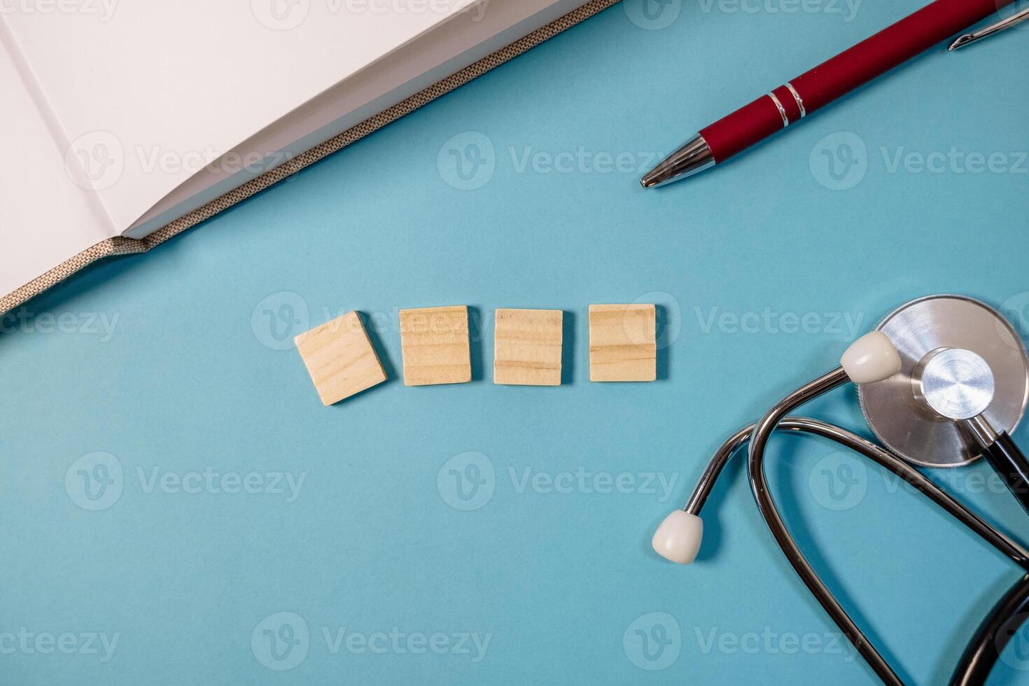 Pen and a stethoscope are on a blue surface photo