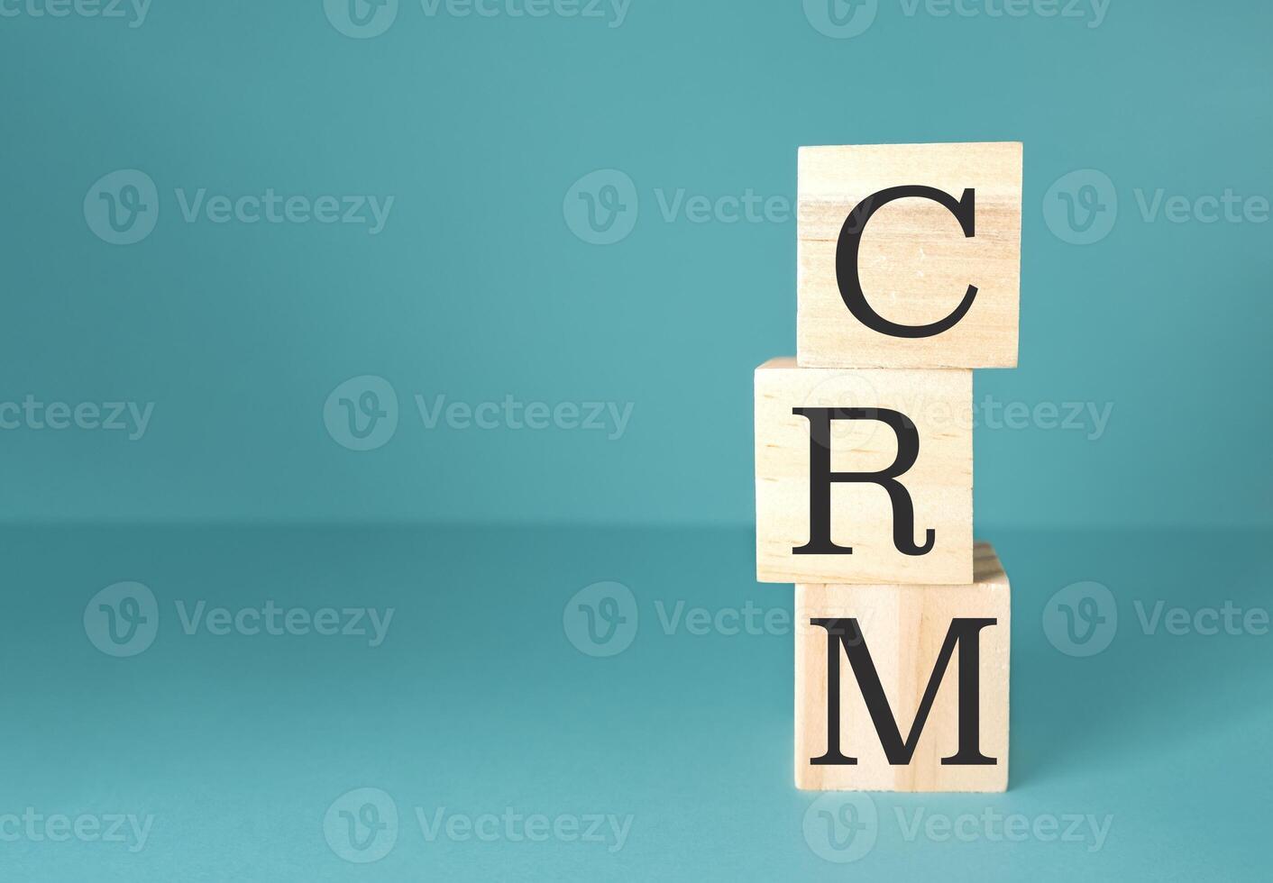 Stack of wooden blocks with the letters CRM on top photo