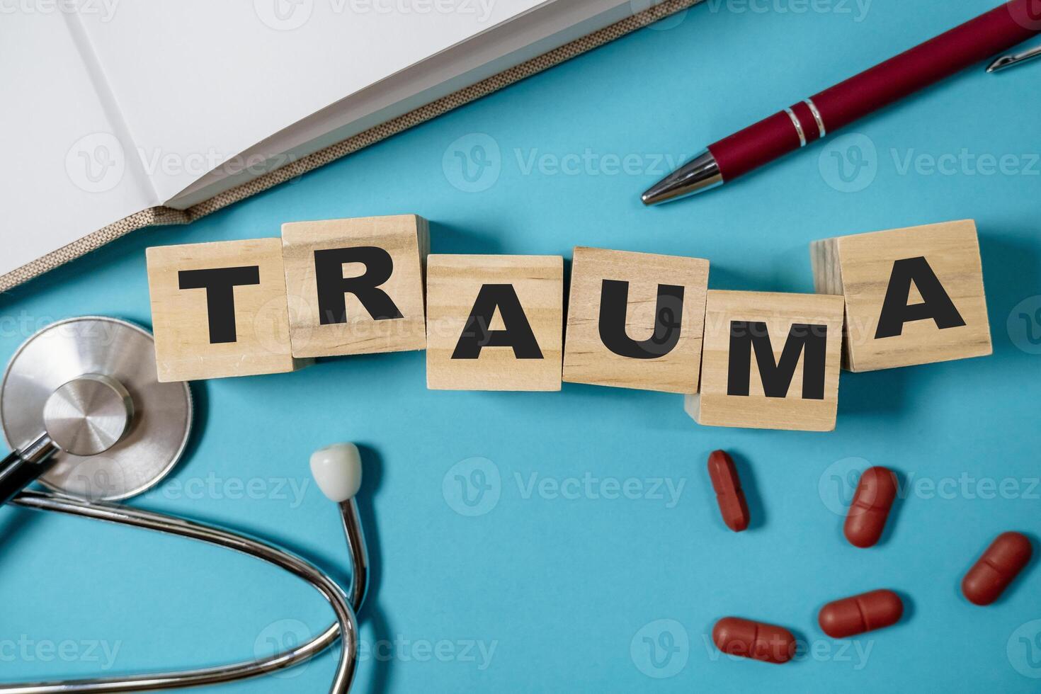 Stack of wooden blocks spell out the word trauma photo